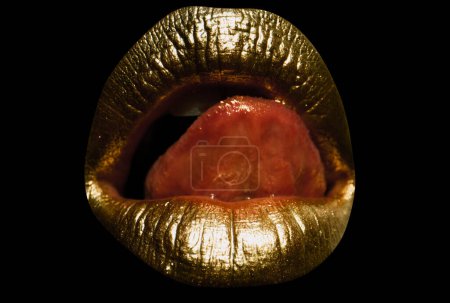 Téléchargez les photos : Lèvres dorées avec art créatif rouge à lèvres métallique doré. Peinture dorée sur les lèvres d'une fille sexy. Bouche de femme sensuelle, fond isolé. Femme isolée bouche dorée avec langue sortie - en image libre de droit