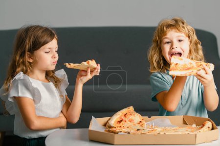 Photo for Hungry children eating pizza. Excited kids eating pizza - Royalty Free Image