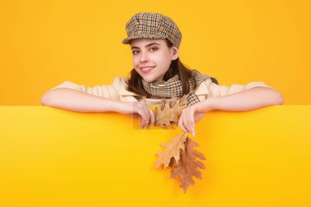 Foto de Mujer retrato de otoño con hojas de arce de otoño en el estudio aislado de fondo con espacio de copia. Retrato de otoño de mujer alegre con hojas de otoño con sombrero de boina y bufanda cálida de otoño - Imagen libre de derechos