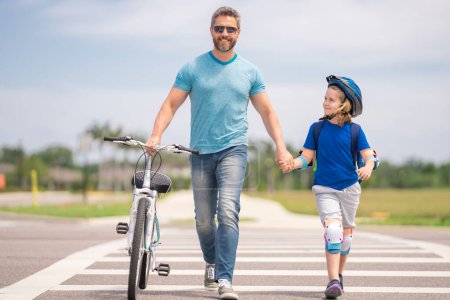 Safety on road. Pedestrian crossing for cyclists. Father teaching son cycling. Father and son learning to ride a bicycle at Fathers day. Father support and helping son. Child care. Insurance child