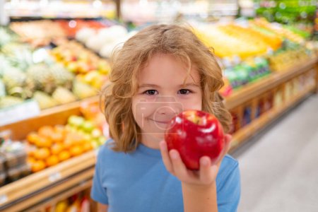 Téléchargez les photos : Portrait d'enfant avec panier plein de légumes frais dans un magasin d'aliments. Supermarché et concept d'épicerie. Faire du shopping. Un enfant achète de l'épicerie au supermarché. tenir le panier - en image libre de droit