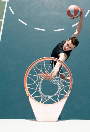 Photo for American basketball player scoring a slam dunk - Royalty Free Image