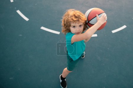 Photo for Kid boy concentrated on playing basketball. Basketball kids school - Royalty Free Image
