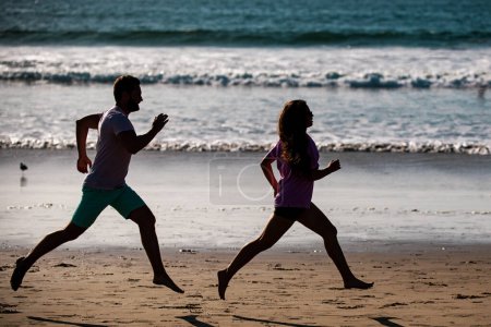 Photo for Young man and woman running jogging along the sea. Couple running on beach - Royalty Free Image