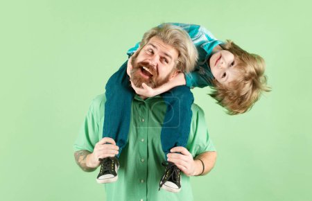 Téléchargez les photos : La fête des pères. Père donnant drôle excité fils piggyback. Famille heureuse - en image libre de droit