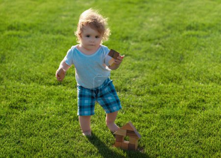 Photo for Insurance kids. Baby boy toddler walking in a park on bright spring day - Royalty Free Image