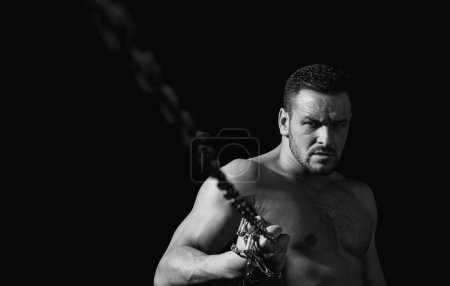 Photo for Seductive face of a sexy man athlete holding a chain. Macho looking confident. Strong muscular male body, muscles guy - Royalty Free Image