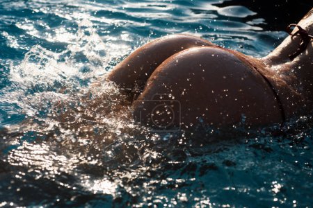 Photo for Sexy curves girl butt in bikini in pool. Sexy buttocks. Young woman shows a beautiful ass buttocks in water. Summer background - Royalty Free Image