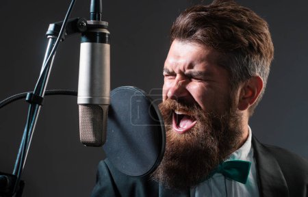 Téléchargez les photos : Chanteuse de karaoké. Homme chantant avec microphone de musique. Musique classique - en image libre de droit
