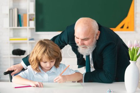 Photo for Help to learn. Schoolboy learning in classroom. School teacher, education, teachering. Pupil kid lesson - Royalty Free Image
