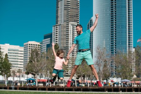 Photo for Father and son jumping on urban street background. Weekend activity happy family lifestyle concept - Royalty Free Image