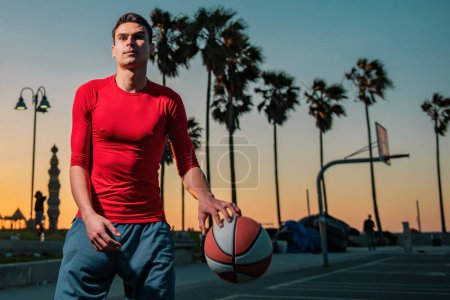 Photo for Action shot of young man playing basketball outdoors - Royalty Free Image