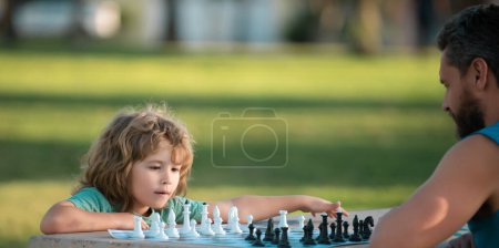 Téléchargez les photos : Père et fils jouant aux échecs passent du temps ensemble dehors. Jeux et activités pour enfants - en image libre de droit