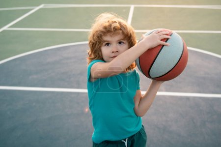 Foto de Niño jugando baloncesto. Lindo niño sosteniendo una pelota de canasta tratando de hacer un marcador. Deporte para niños - Imagen libre de derechos