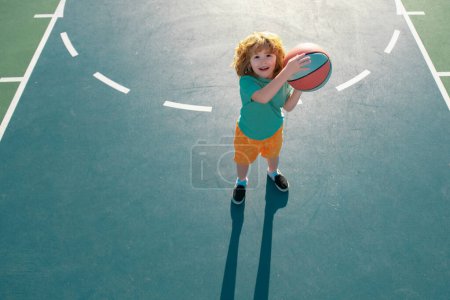 Téléchargez les photos : Mignon enfant petit garçon entraînement basket-ball. École de basket enfants - en image libre de droit