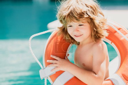 Foto de Salvavidas. Vacaciones de verano. Feliz niño jugando con la boya salvavidas. Una niña de verano. Salvar la vida - Imagen libre de derechos