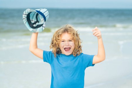 Photo for Excited child funny face. Excited child with thumbs up on sea summer beach. Expressive emotional face. Funny expressive emotional boy play on summer beach. Amazed child enjoying summer life - Royalty Free Image