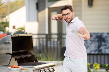 Photo for Men cooking on barbecue grill in yard. Cook at a barbecue grill preparing salmon - Royalty Free Image