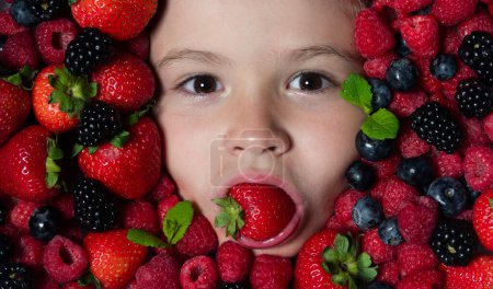 Téléchargez les photos : Les enfants font face avec des fruits de baies fraîches. Mélange assorti de baies fraise, myrtille, framboise, mûre. Baies nutritionnelles saines pour les enfants. arrière-plan Berry - en image libre de droit