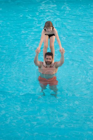 Photo for Father and son have fun in pool. Dad with child splashing in pool water. Father and son playing together in swimming pool. Dad and little kid swimming in summer swimming pool. Family summer vacation - Royalty Free Image