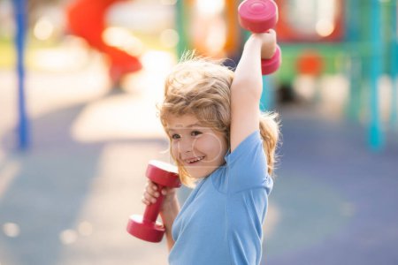 Photo for Kids sport training on playground outdoor. Child boy working out with dumbbells. Kids sport and active healthy life. Sport and kids training - Royalty Free Image