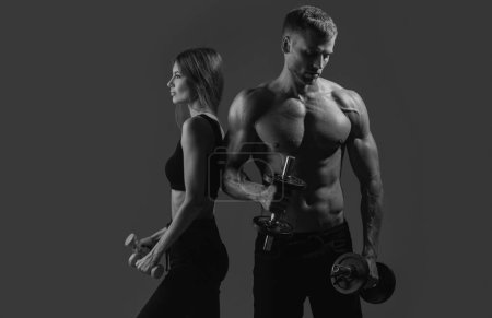 Photo for Fitness models pumping up arm with dumbbell. Couple exercising with dumbbells together. Sexy strong fit body. Couple training with dumbbell - Royalty Free Image