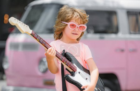 Téléchargez les photos : Drôle de gosse rock avec guitare. Concept de passe-temps musical - en image libre de droit