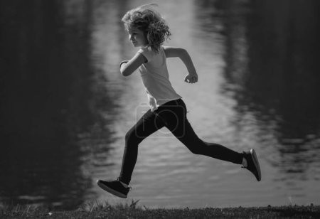 Photo for Kids jogging in park outdoor. Little boy running in nature. Run movement - Royalty Free Image