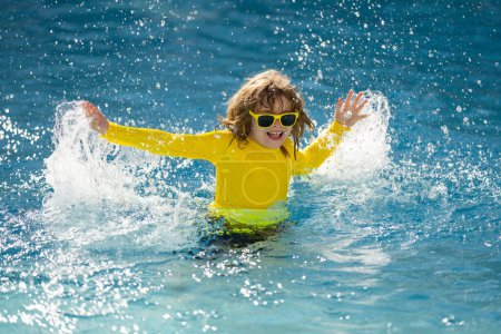 Téléchargez les photos : Enfant profitant de vacances d'été, nageant dans la piscine. Enfant s'amuser pendant les vacances d'été à la piscine. Des enfants heureux jouant sur l'eau de la piscine. Enfants heureux en vacances d'été jouent dans l'eau - en image libre de droit