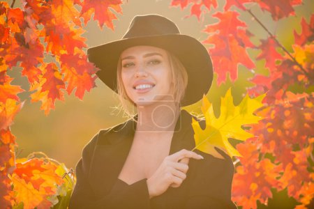 Photo for Beautiful girl outdoors in autumn fall. Young woman collects yellow fall leaves in autumn. Beauty woman holds autumn yellow leaf fall the face. Portrait of sensual woman over autumn fall background - Royalty Free Image