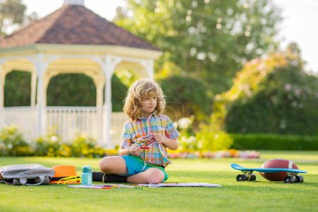 Photo for Kid boy create artist paints, summer vacation. School child drawing in summer park, painting art. Little painter draw pictures outdoor - Royalty Free Image