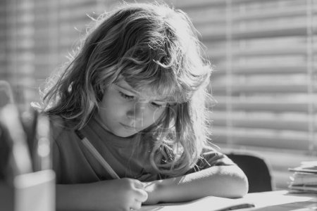 Photo for Child writing at school. Preteen schoolboy doing her homework at home. Child study. Education and learning for kids. Cute little boy doing homework in classroom - Royalty Free Image