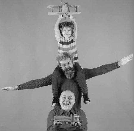 Foto de Generación de hombres: abuelo padre y nieto jugando con avión de juguete. Chico sueña con convertirse en piloto. Viaje viaje concepto de viaje. Aislado. Familia de generaciones - Imagen libre de derechos