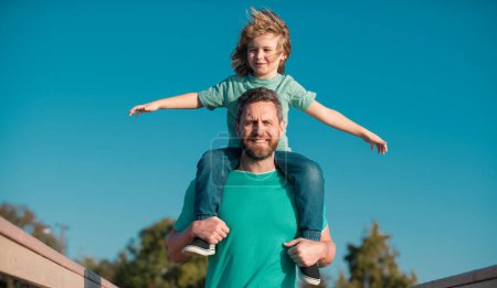 Photo for Handsome father piggybacking son playing on nature, daddy holding riding on back adorable cheerful kid boy enjoy active game - Royalty Free Image
