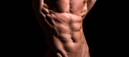 Foto de Hombre atlético fuerte mostrando cuerpo muscular y abdominales de seis paquetes sobre negro aislado - Imagen libre de derechos