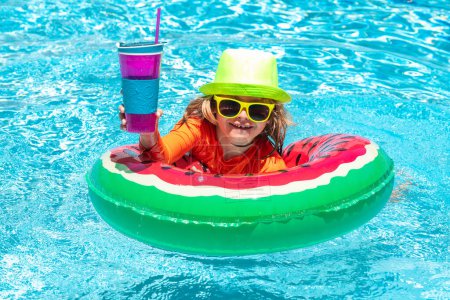 Téléchargez les photos : Enfant dans la piscine. Activité estivale. Mode de vie sain des enfants. Jouets d'eau pour enfants. Les enfants jouent dans une station tropicale - en image libre de droit