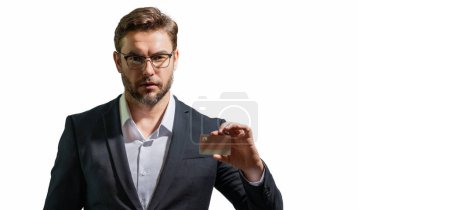Photo for Man with a credit card to review statements. Credit cards purchases online. A businessman with a credit card with credits history making payments. Credit card offers. Banner for header, copy space - Royalty Free Image