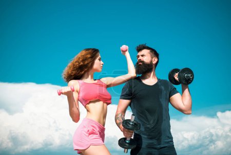 Photo for Man and woman training with dumbbells, athletic sport couple exercise outdoor - Royalty Free Image