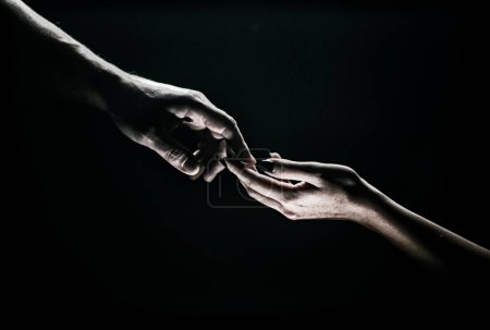 Foto de Dos manos acercándose. Ternura, manos tiernas en fondo negro. Un toque romántico con los dedos, amor. Creación de mano de adam - Imagen libre de derechos