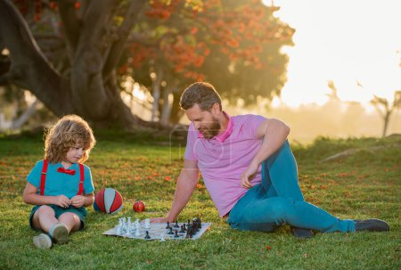 Photo for Father and son playing chess spending time together outdoor. Child learning to play chess. Little boy think or plan chess game. Checkmate - Royalty Free Image