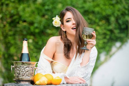 Foto de Atractiva mujer sexy bebiendo vino al aire libre. Hermosa hembra tomando una copa de vino. Joven modelo hermoso en vacaciones vacaciones al aire libre. Estilo de vida al aire libre moda mujer bonita disfrutando de la primavera - Imagen libre de derechos