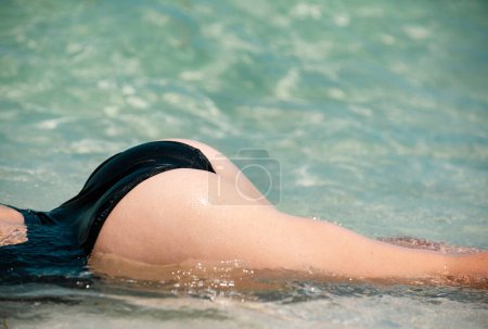 Téléchargez les photos : Summer vacation. Sexy woman butt in water. Girl buttocks in bikini. Summertime woman holidays on sea - en image libre de droit