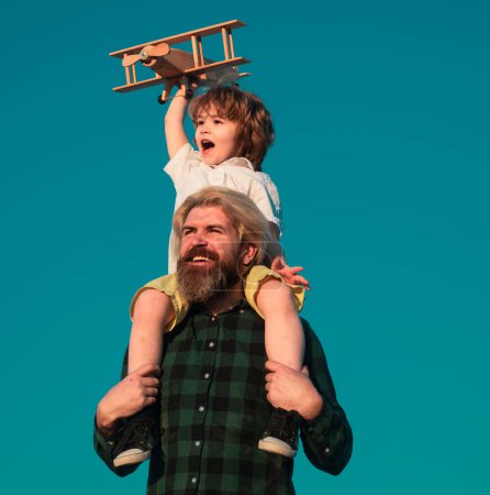 Téléchargez les photos : Père et fils jouant avec un avion en bois. Le temps en famille ensemble - en image libre de droit