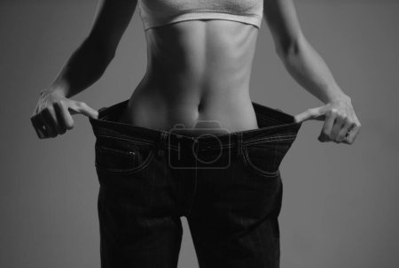 Téléchargez les photos : Slim waist. Oversized womans pants trousers in weight loss concept. Woman in dieting concept with big jeans - en image libre de droit