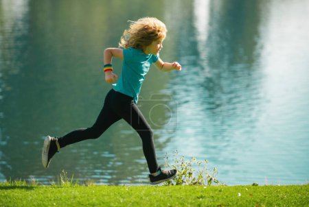Foto de Corredores de niños corren en el parque. Deportivo joven jogging y entrenamiento al aire libre. Correr ayuda al cuerpo a ser fuerte - Imagen libre de derechos