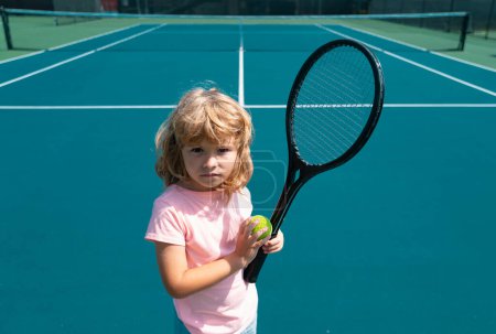 Photo for Child with tennis racket and ball on tennis court outdoor. Sport exercise for kids. Summer activities for children. Training for young kid. - Royalty Free Image