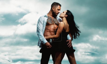 Photo for Fashion couple of lovers kissing and hugging. Romantic couple dating. Couple in love. Athletic shirtless muscular man kissing and embracing romantic woman. Sexy elegant couple in the tender passion - Royalty Free Image