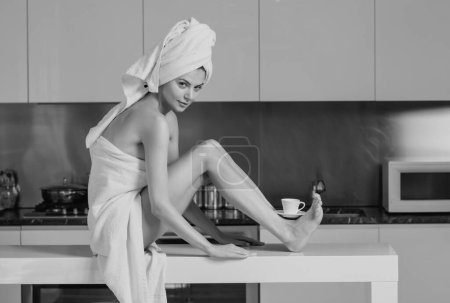 Téléchargez les photos : Femme sexy avec tasse de café sur de longues jambes. Sensuelle fille dans la cuisine le matin - en image libre de droit