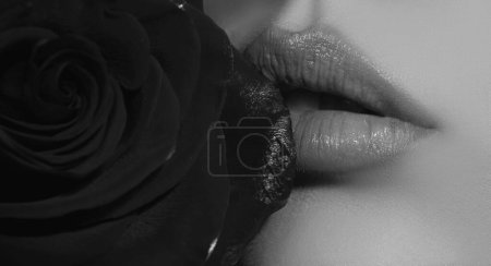 Foto de Female mouth with sexy red lips isolated closeup. Close up woman sensual lips with red lipstick and red rose. Passionate lip - Imagen libre de derechos