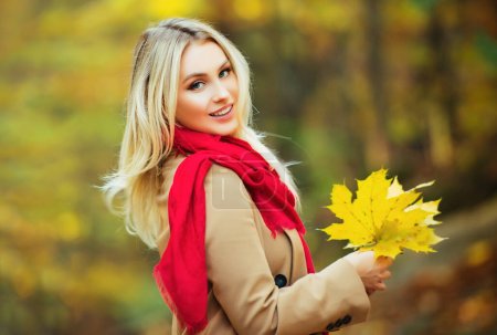 Foto de Mujer joven caminando en un parque de hojas de otoño - Imagen libre de derechos